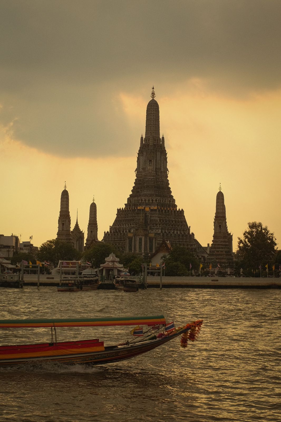 Wat Arun at dusk with a longtail boat on the river
