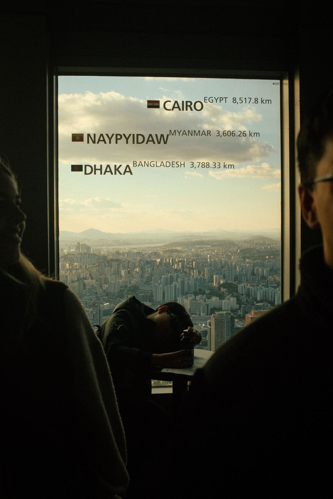 A man asleep at an observation window in Seoul